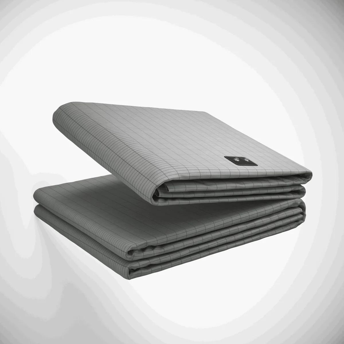 Terra grounding sheet by The Grounding Co: a grey silver-threaded sheet folded on a white background beside its black grounding connector.